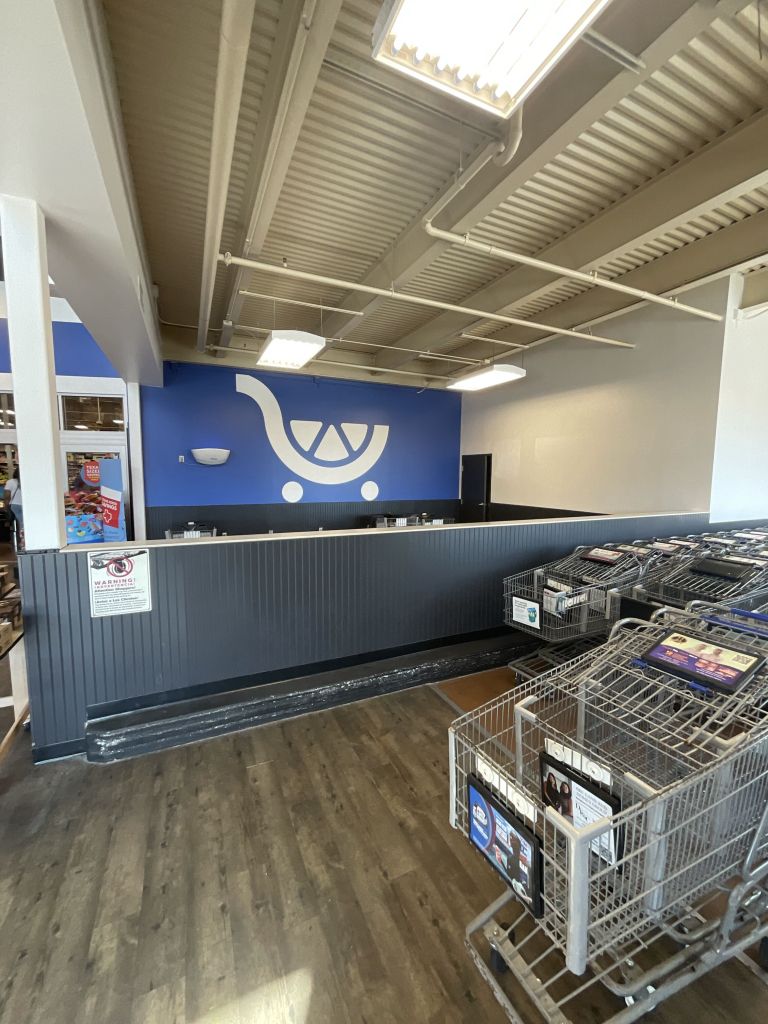 Cart corral with painted cart logo on blue wall and dark marlite