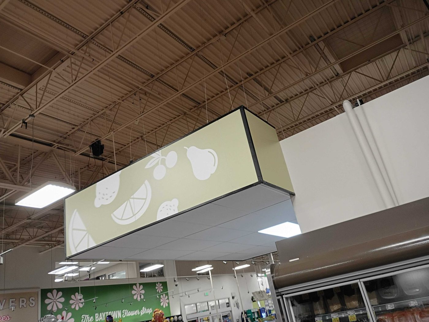 Overhead produce signage and floral department graphics